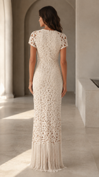 Back view of cream short sleeve crochet-look maxi dress with floor-length fringe hem
