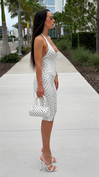 Side view of white polka dot halter knee-length jumpsuit