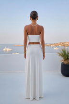 Back view of model in white two-piece maxi skirt set
