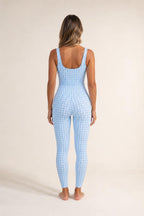Back view of model wearing light blue plaid active jumpsuit