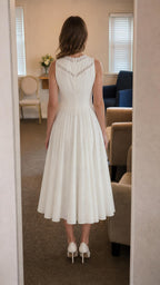 Back view of model showing back neckline lace detail on white dress