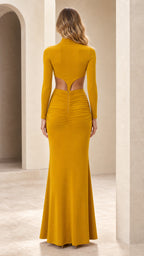 Back view of woman showing cutout detail on mustard yellow crop top and skirt