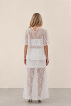 Back view of woman wearing white lace two-piece outfit