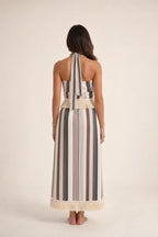 Back view of model wearing beige stripe halter fringe maxi dress