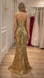 Back view of model showcasing trailing hem of gold sequin dress