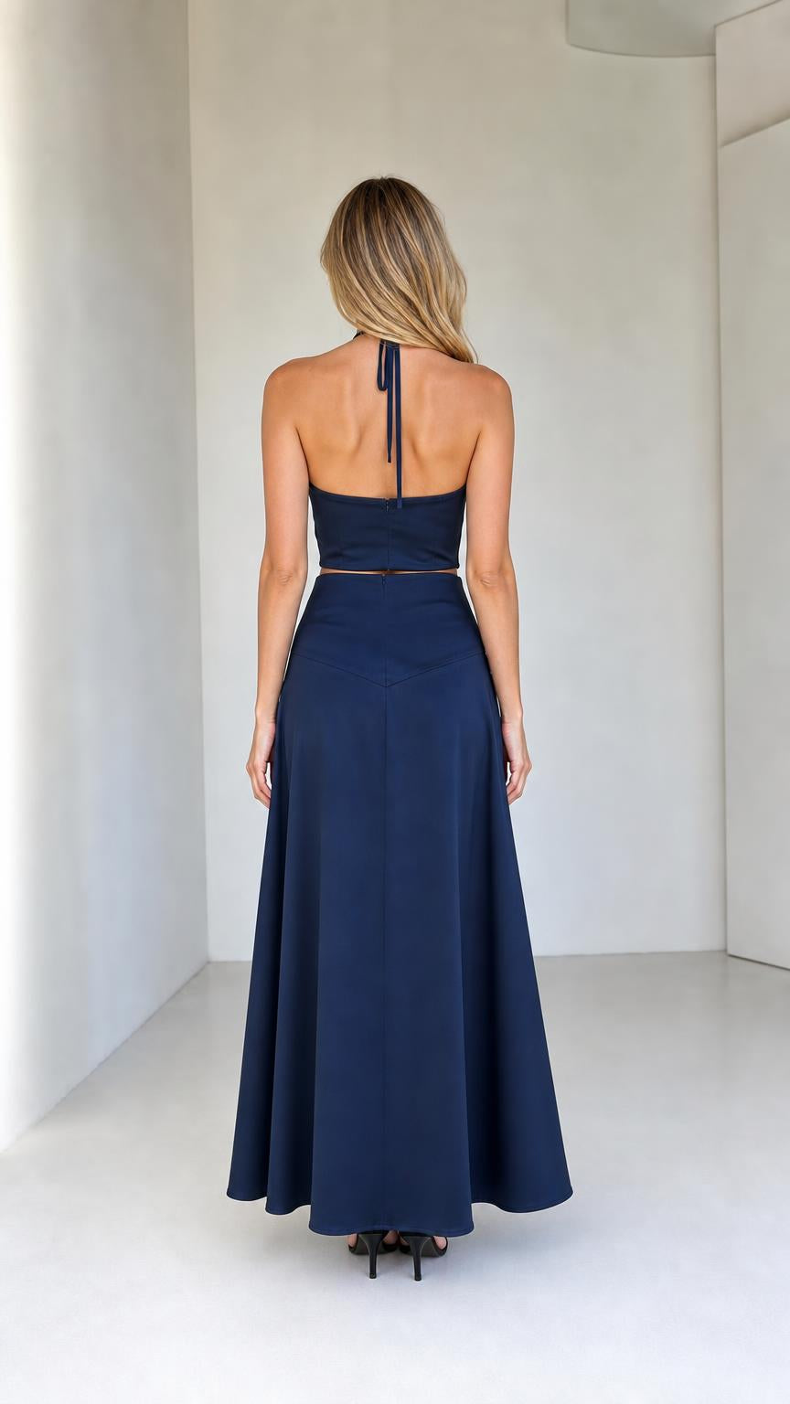Back view of model wearing navy halter crop top and maxi skirt