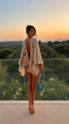 Back view of ivory printed romper cover-up set with dramatic open-back drape