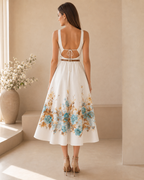 Back view of a white floral midi dress with open back and tie detail
