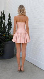 Back view of model wearing pink strapless mini dress