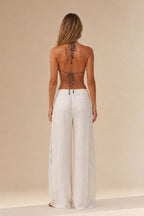 Back view of woman wearing white cutout wide leg trousers