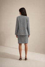 Back view of model wearing houndstooth blazer and skirt set