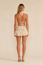 Back view showing open back and strap details of champagne romper