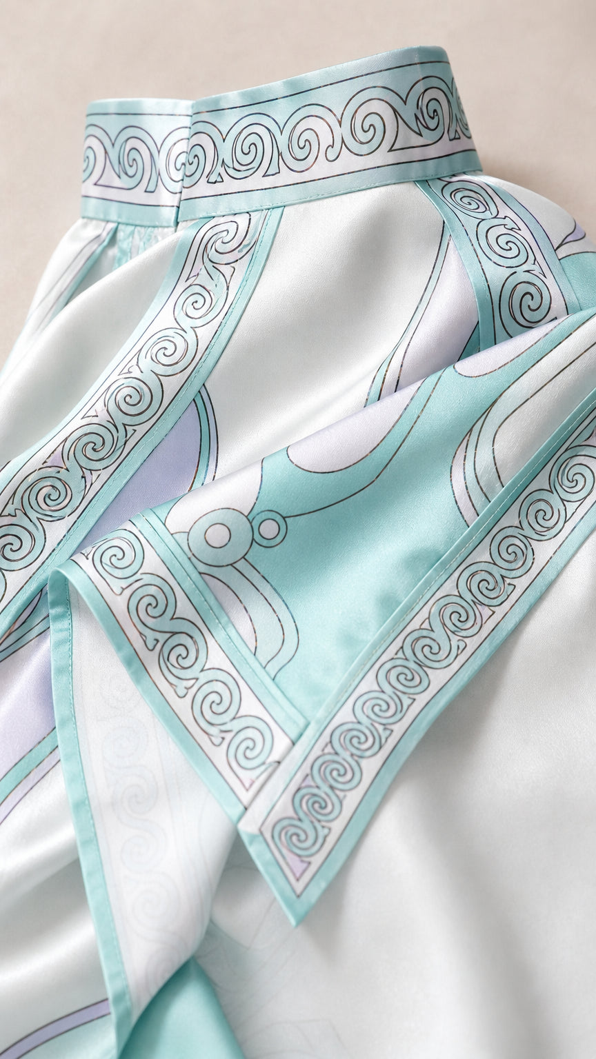 Close-up detail of satin fabric and swirl pattern on light blue dress