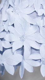 Close-up detail of 3D floral appliques on light blue fabric