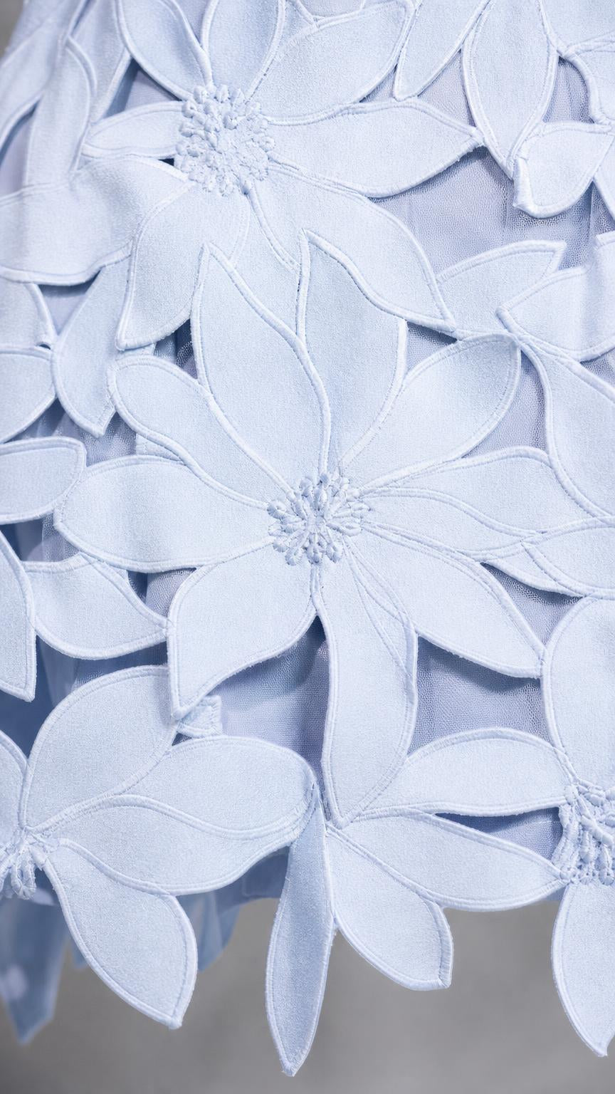 Close-up detail of 3D floral appliques on light blue fabric