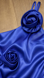Close-up of fabric texture and rosette appliques on royal blue dress