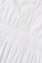 Close-up detail of white fabric, smocked waist, and lace trim