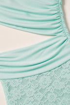 Close-up detail of waist cutout and lace texture on mint dress