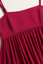 Close-up detail of the square neckline and gathered empire waist on fuchsia dress