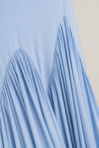 Close-up detail of pleated chevron hem on light blue dress