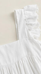 Close-up detail of white ruffled shoulder strap and fabric texture