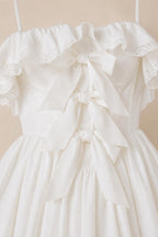 Close-up detail of front bodice bows and ruffles on white dress