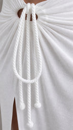 Close-up of decorative rope tie detail on white skirt
