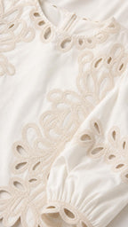 Close-up detail of white embroidery and cutout fabric