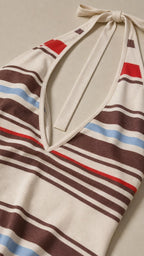 Close-up detail of cream dress halter neckline and striped pattern