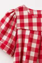 Close-up detail of red gingham check fabric and shoulder pleats