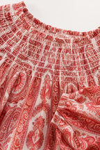 Close up of red paisley print smocked neckline