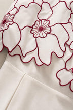 Close-up detail of contrast floral embroidery and scalloped overlay