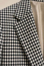 Close-up detail of the woven houndstooth fabric texture and lapel