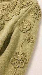 Close-up detail of crochet floral appliques on Sage Green knit sleeve