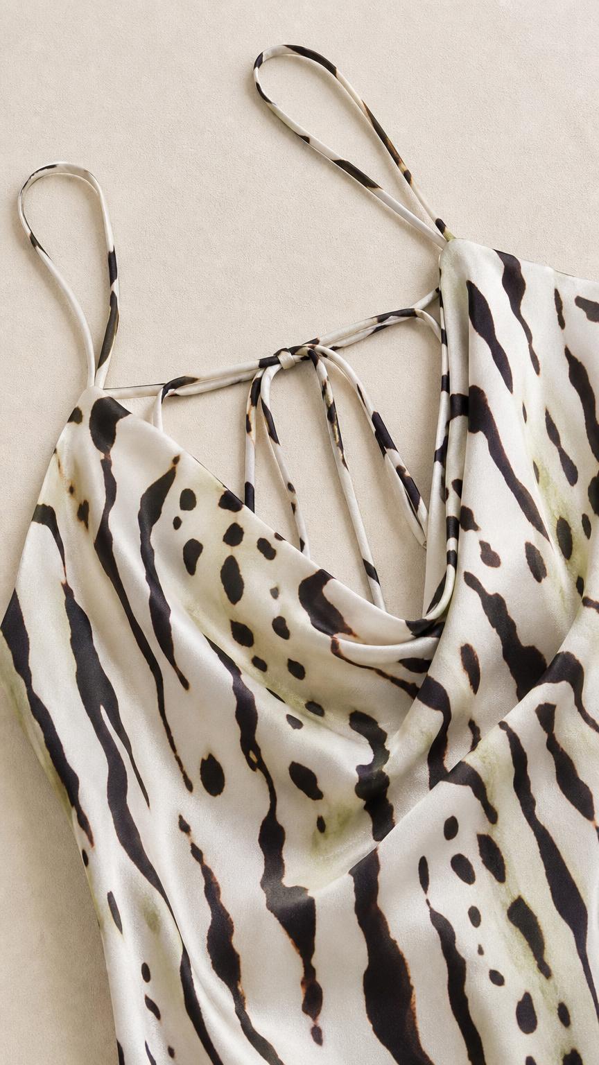 Close-up detail of cowl neckline and straps on animal print slip dress