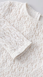 Close-up detail of textured white floral lace fabric and collar