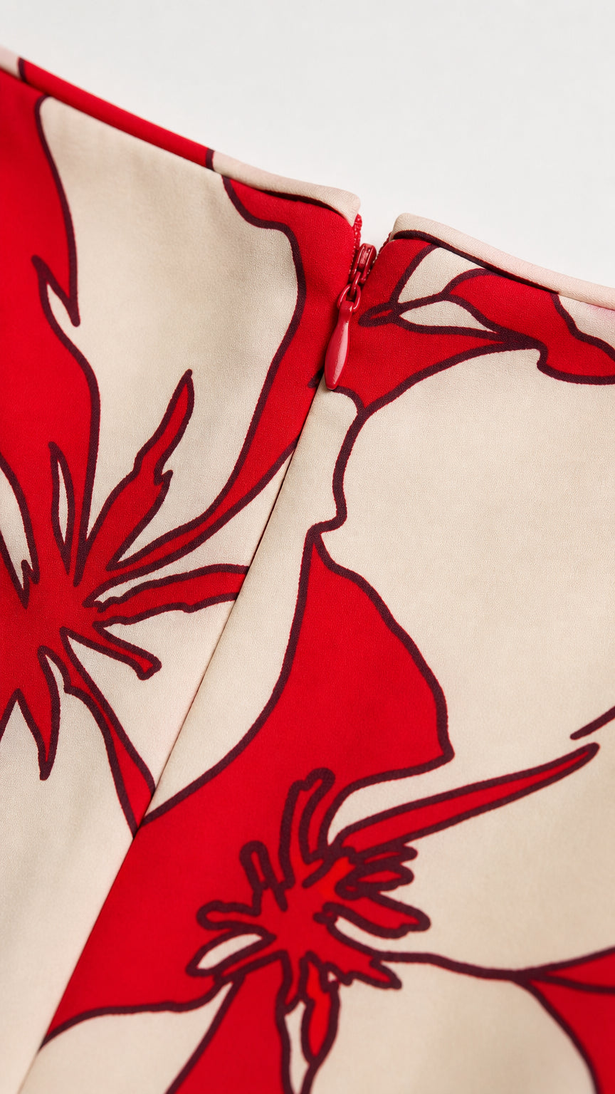 Close-up detail of side zipper and red-white floral fabric pattern