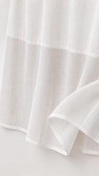 Close-up detail of white dress fabric and hem