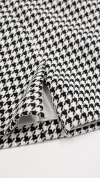 Close-up of black houndstooth fabric and hem detail