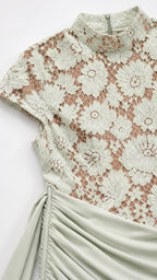 Close-up detail of sage green floral lace bodice and ruched skirt