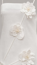 Close-up detail of 3D floral appliques with pearl centers on white dress