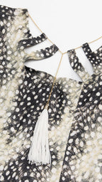 Close-up of the cutout neckline and tassel detail on the dress