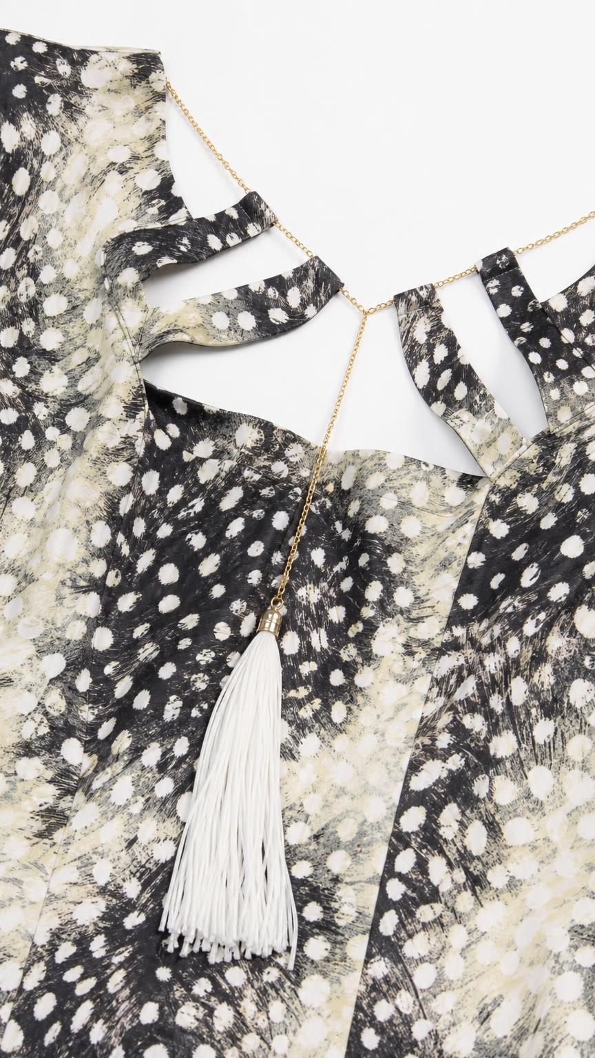 Close-up of the cutout neckline and tassel detail on the dress