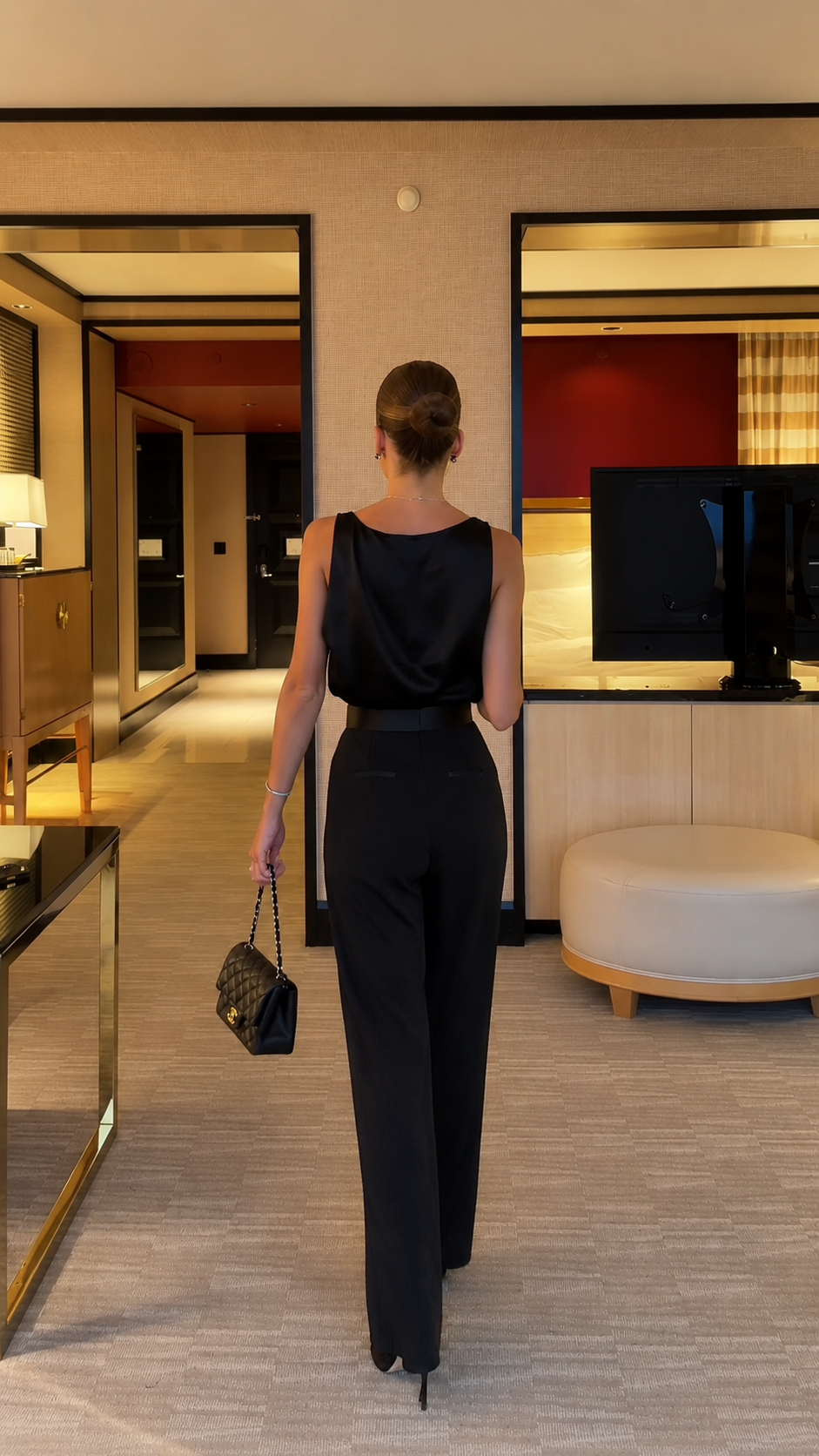 Back view of black full-length sleeveless jumpsuit with tailored wide leg silhouette