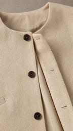 Close-up detail of the beige top neckline and button closure