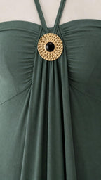 Close-up of metallic ring accent on green dress neckline