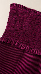 Close-up detail of smocked bodice and pleating texture in magenta