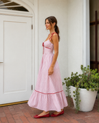 Blush pink striped maxi dress side view with tie straps and flowing skirt
