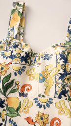 Close-up detail of straps and square neckline on white floral dress