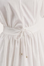 Close-up of drawstring waist detail on white mini dress